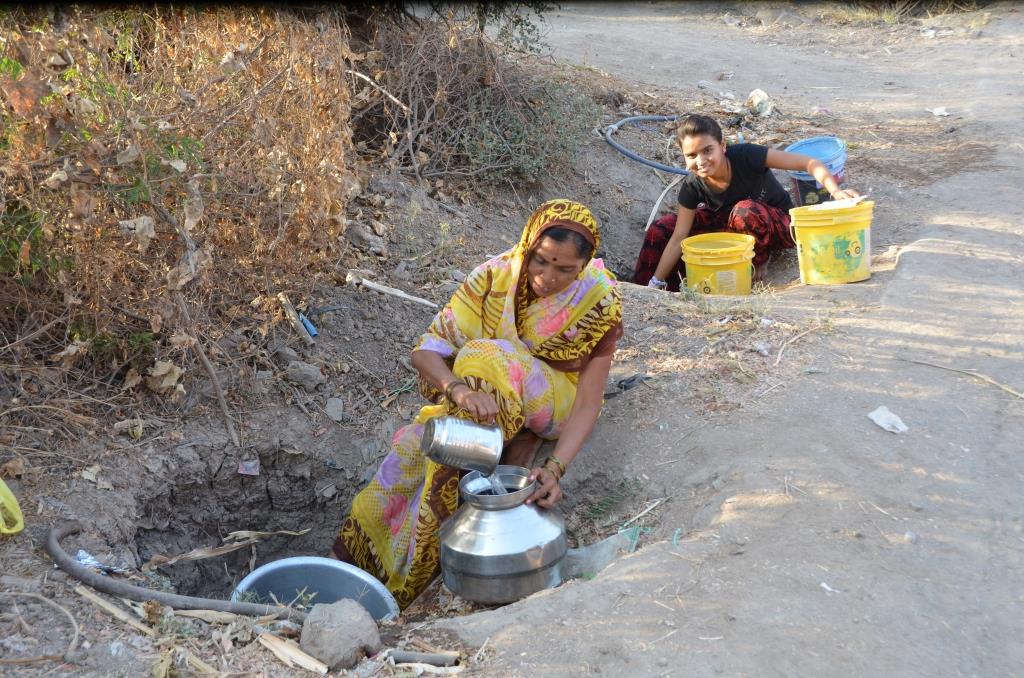 Women filling jugs with groundwater